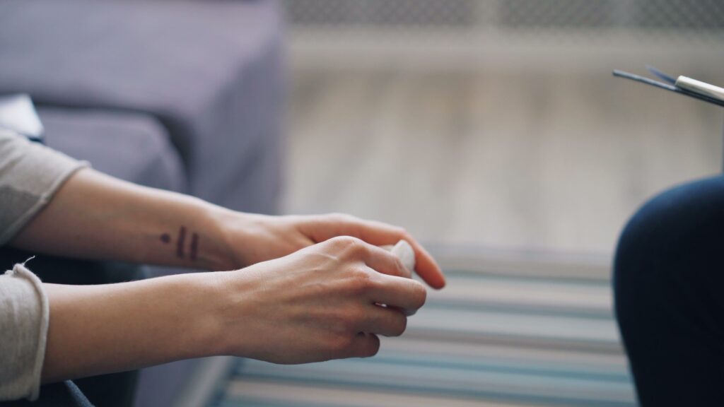 Close-up of hands during therapy session, symbolizing mental health support.